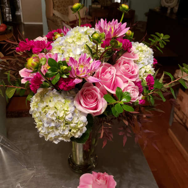 Pink roses and hydrangeas in a glass vase with magenta blooms