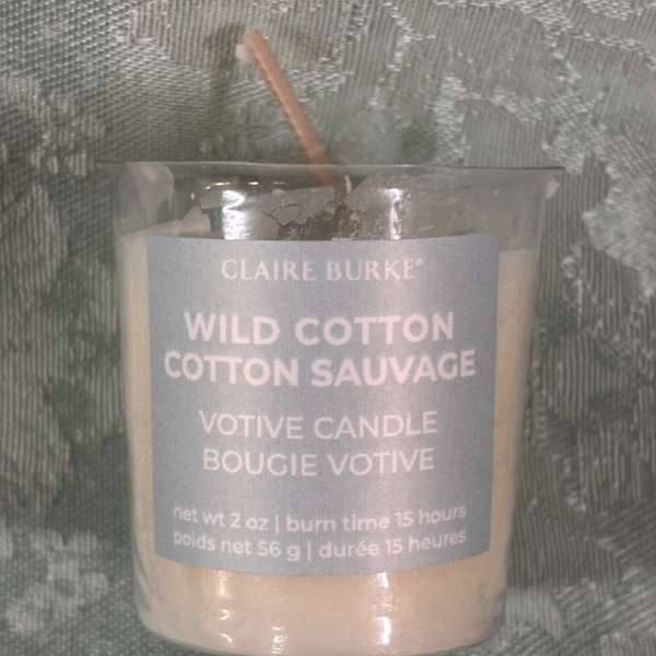 Glass votive candle labeled Wild Cotton Cotton Sauvage