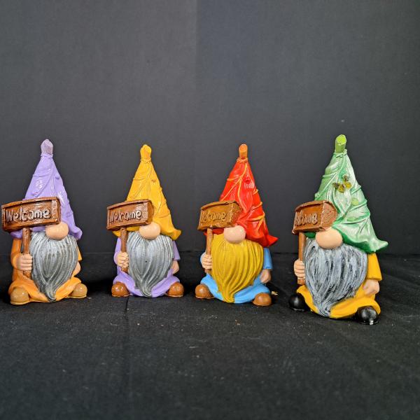 Five colorful gnome figurines holding welcome signs