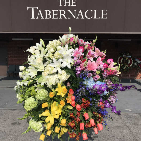 Large standing floral wreath with multicolored lilies and roses