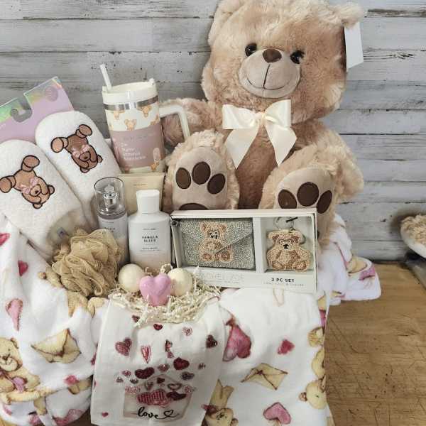 Gift basket with teddy bear, slippers, mug, and blankets