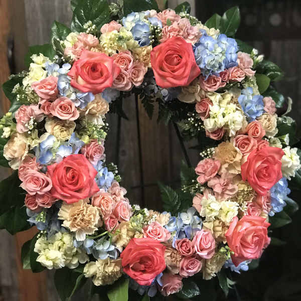 Circular floral wreath with pink roses and pastel hydrangeas