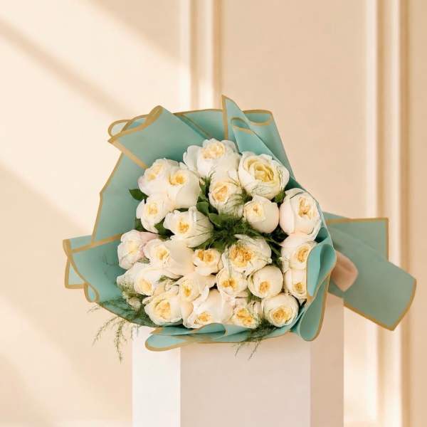 Bouquet of white roses wrapped in teal paper