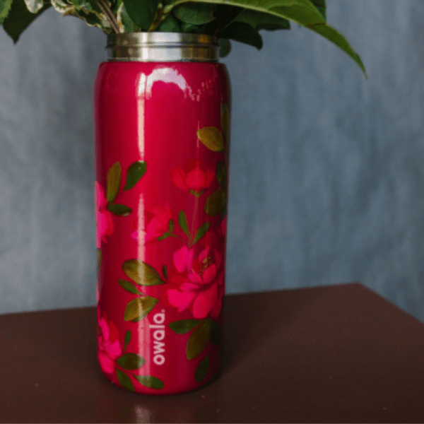 Pink floral insulated tumbler with a metal lid and green leaf pattern