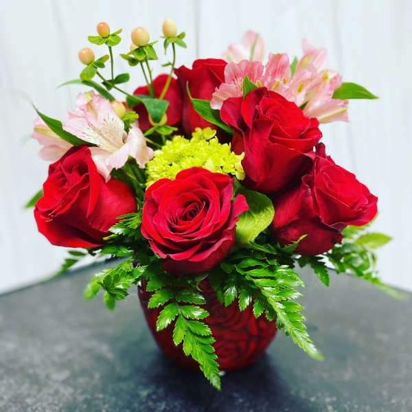 Red roses and pink alstroemeria in a red vase