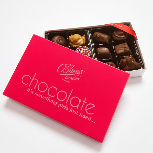 Box of assorted chocolates with a bright pink lid