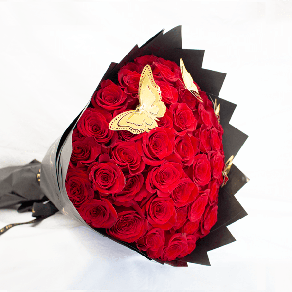 Bouquet of red roses wrapped in black paper with butterfly accents