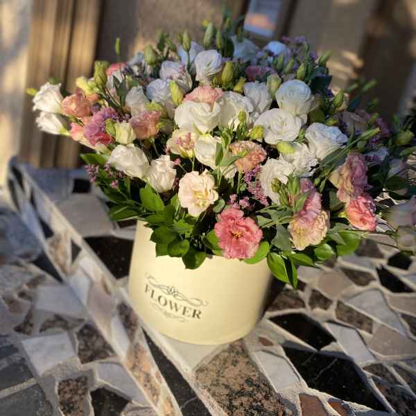 Mixed pink and white flowers in a cream hatbox