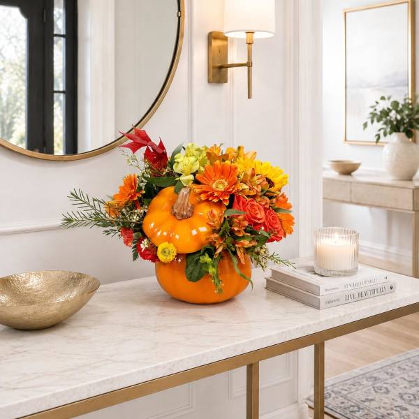 Pumpkin centerpiece with orange and yellow flowers