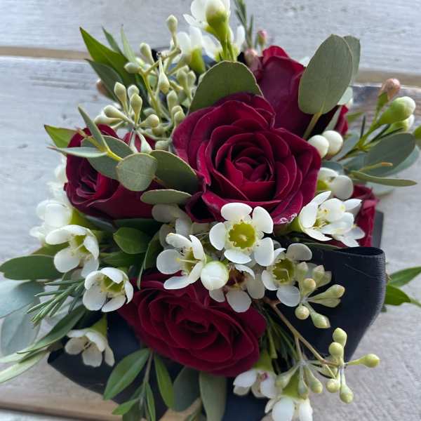 Compact bouquet of deep red roses and white blossoms with eucalyptus