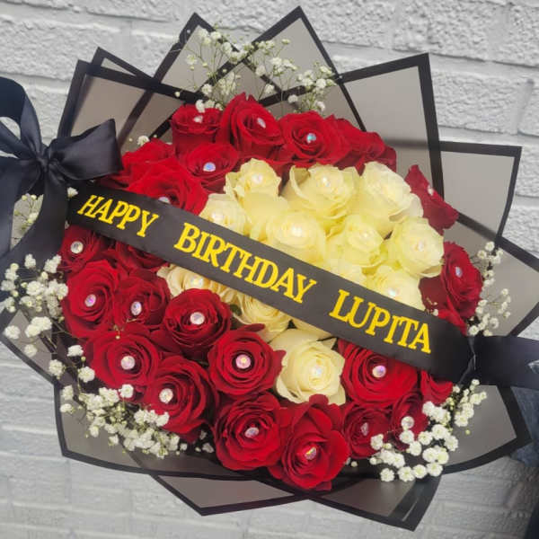 Bouquet of red and pale yellow roses with a birthday ribbon