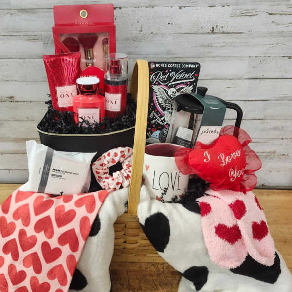 Gift basket with heart-patterned blankets, mug, candles, and beauty items