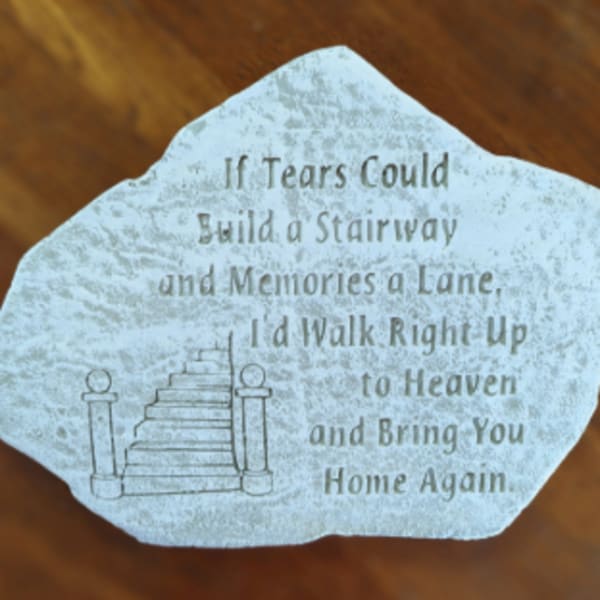 Memorial stone with a staircase illustration and engraved quote
