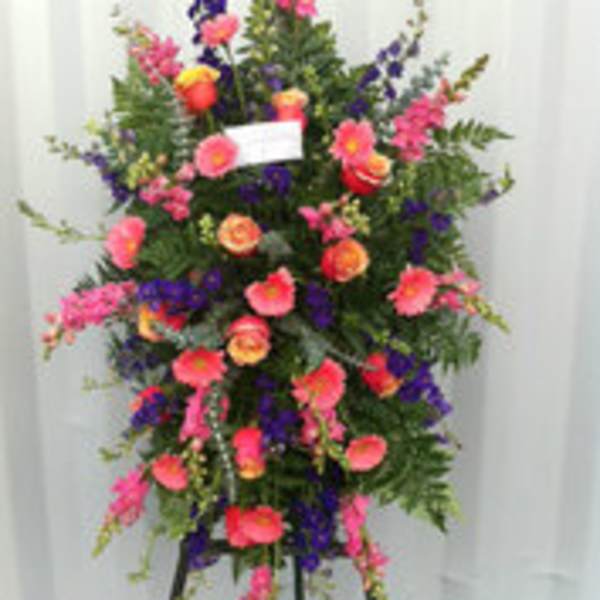 Tall standing floral spray with pink, purple, and orange blooms