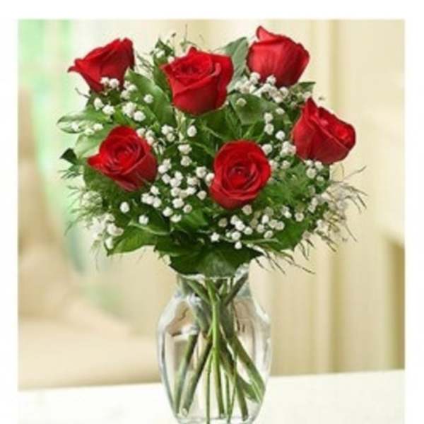 Bouquet of red roses and baby's breath in a clear glass vase