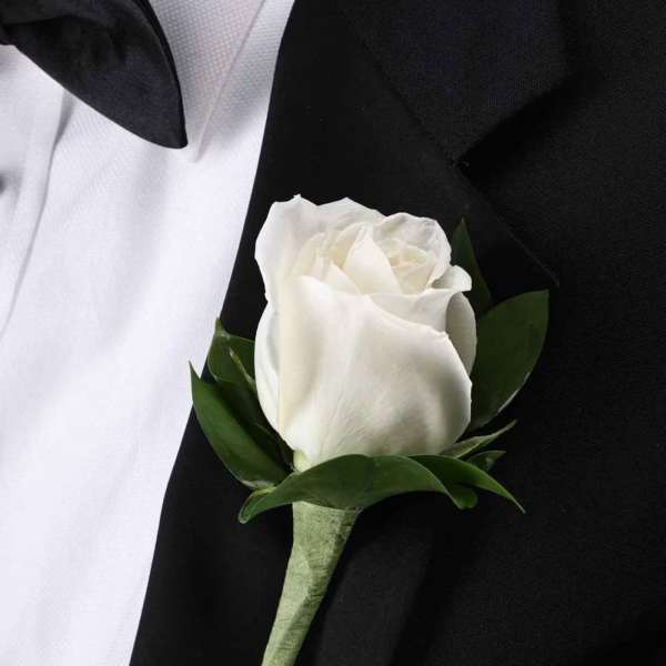 White rose boutonniere on a black suit jacket