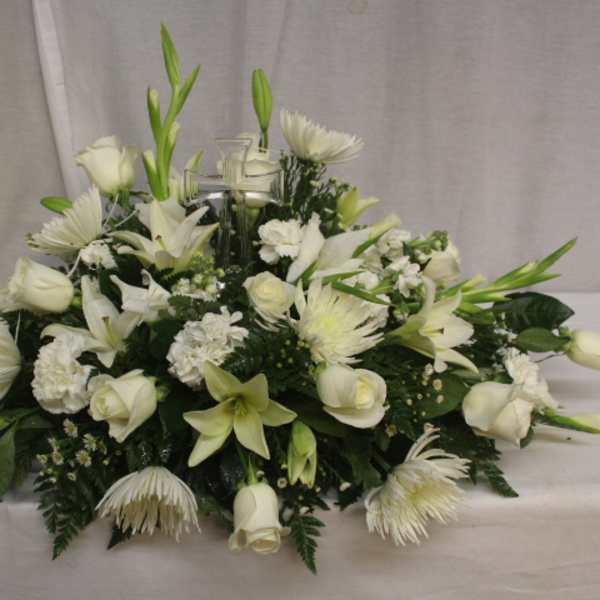 Low white floral centerpiece with roses, lilies, and chrysanthemums