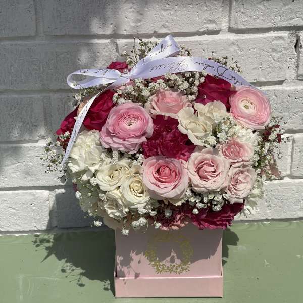 Pink and white rose bouquet in a pink box with a ribbon bow