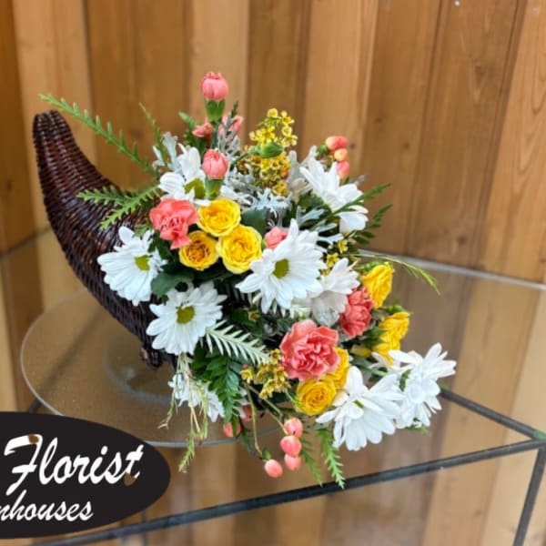 Mixed bouquet in a woven horn-shaped basket with white daisies and pink and yellow flowers