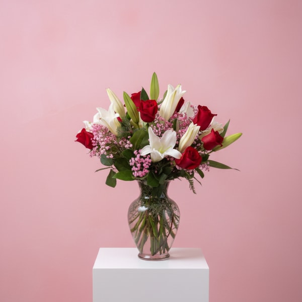 Red roses and white lilies in a clear glass vase