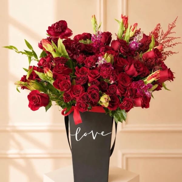 Red rose bouquet in a black box with the word love