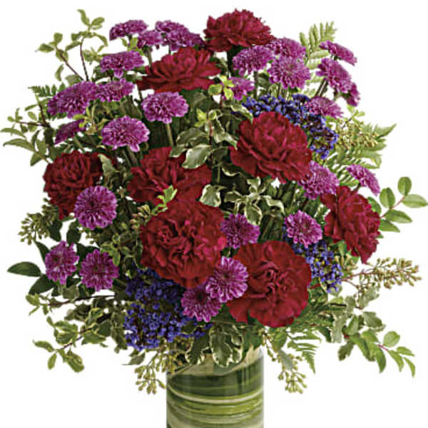Red and purple flowers arranged in a glass vase
