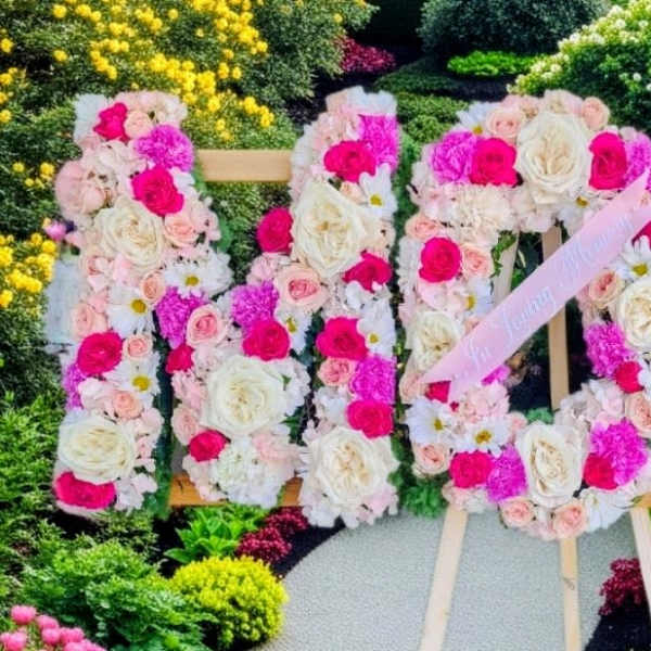 Large floral sign made of pink and white roses on an easel
