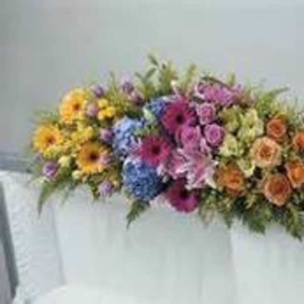 Colorful mixed flower arrangement on a white-draped table