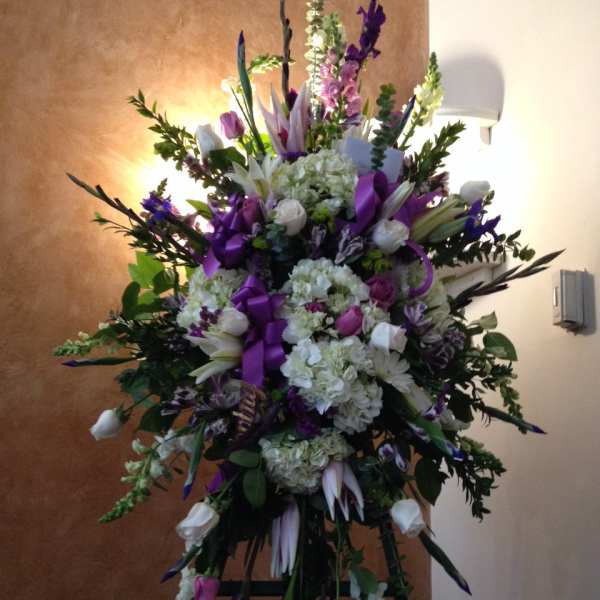 Tall purple and white floral standing spray on an easel