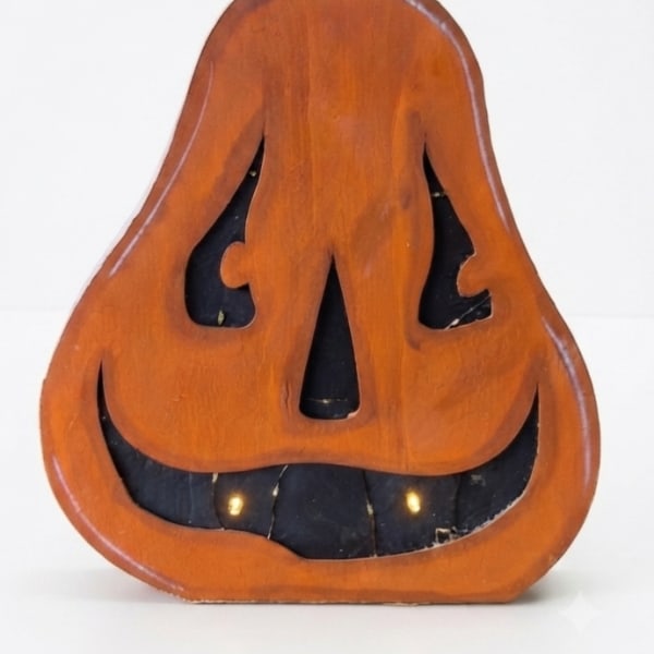 Wooden jack-o'-lantern decoration with a black stem