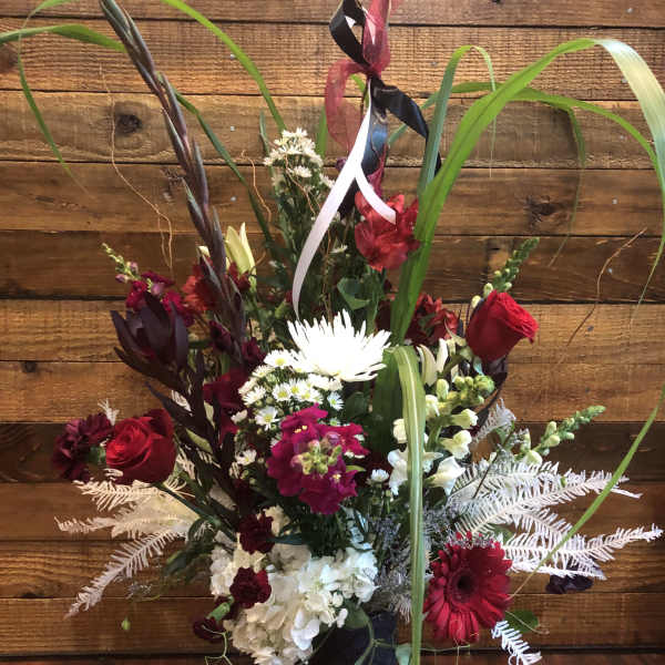 Tall mixed bouquet with red and white flowers in a black vase