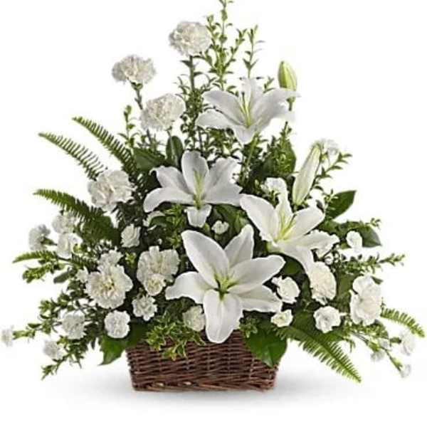 White lilies and carnations in a wicker basket arrangement