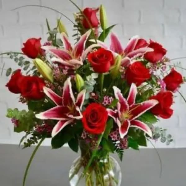 Red roses and pink lilies in a clear glass vase