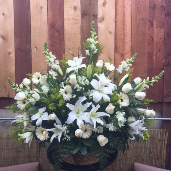 White floral arrangement with lilies and daisies in a basket
