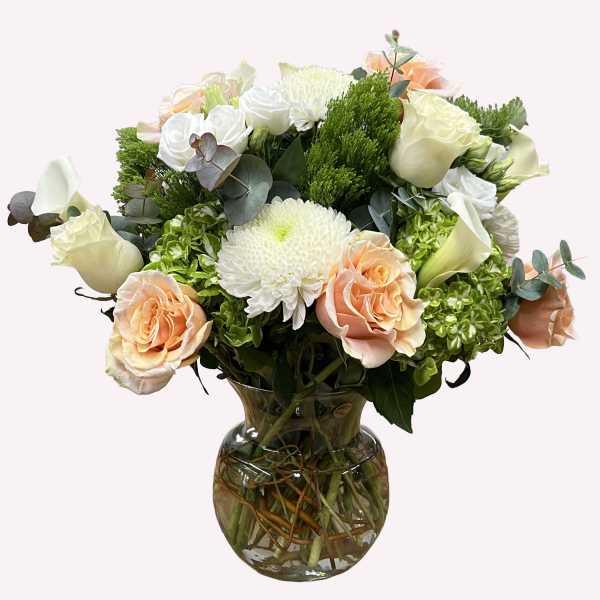 Bouquet of peach and white flowers in a glass vase