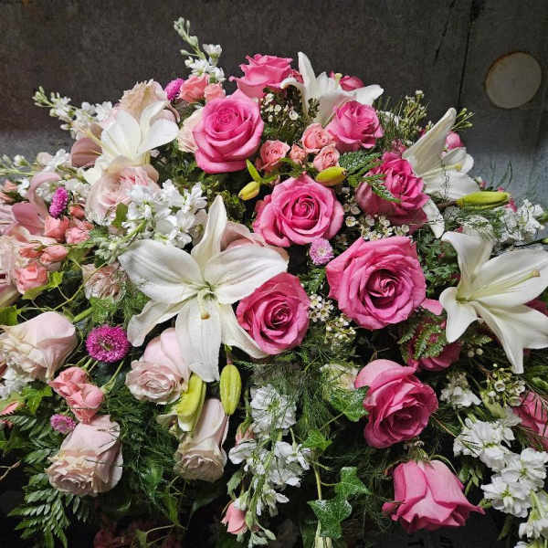 Large bouquet of pink roses and white lilies with mixed filler flowers