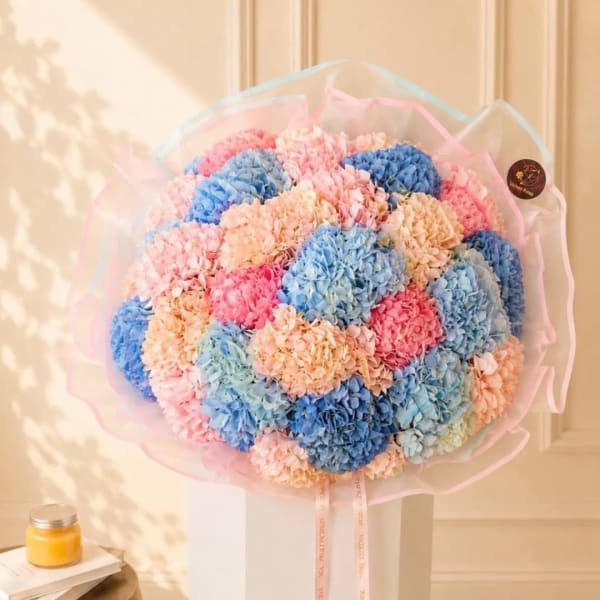 Large pastel hydrangea bouquet wrapped in pink and blue tissue