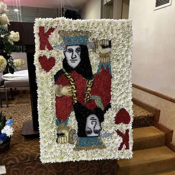 Large floral tribute board with a playing-card design in white flowers