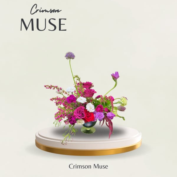 Bright pink and purple floral arrangement in a glass vase