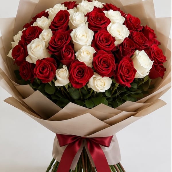 Bouquet of red and white roses wrapped in tan paper with a red ribbon