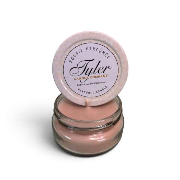 Pink scented candle in a glass jar with a lid