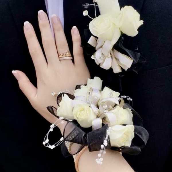 White rose boutonniere and wrist corsage on a suit and wrist