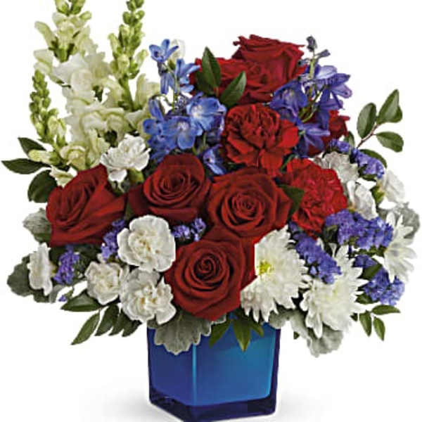 Red roses, white flowers, and blue blooms in a blue vase