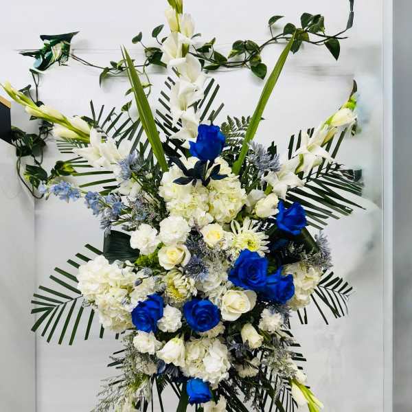 Large standing floral spray with white and blue flowers on an easel