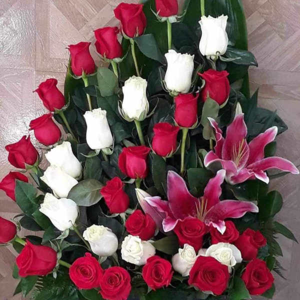 Large arrangement of red and white roses with pink lilies