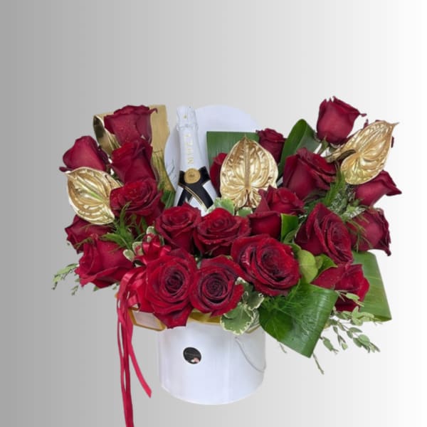 Red roses arranged in a white hat box with gold accents