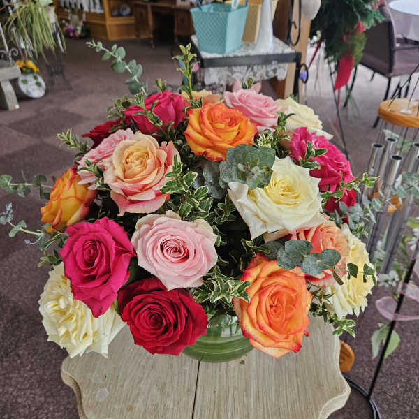 Mixed roses in a glass vase on a table