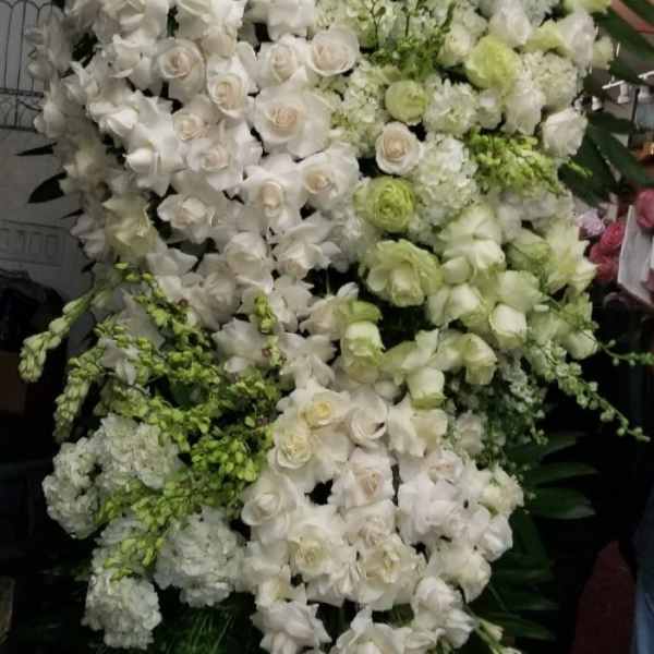 Large white and pale green floral standing spray with roses and orchids