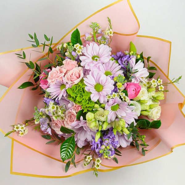 Bouquet of pink, lavender, and white flowers wrapped in pink paper