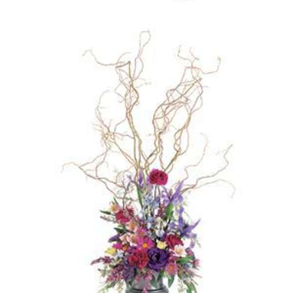 Tall floral arrangement with colorful blooms in a silver vase